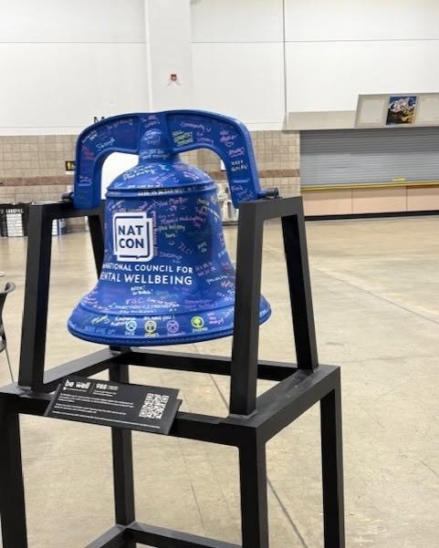 Image of a blue bell with the NatCon logo