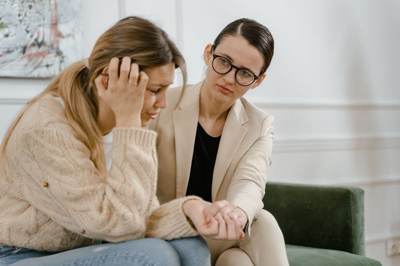 A therapist comforts a woman who is experiencing depression